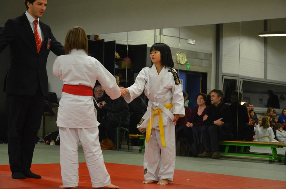 Jonge judoka's schudden elkaar de hand na een wedstrijd
